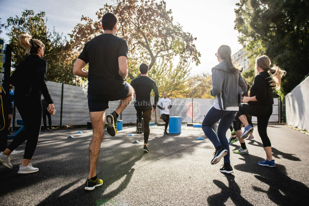 Gruppe macht Fitnessübungen draußen beim Aufwärmen
